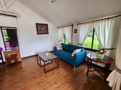 sala de estar con sofá azul y mesa en MB Camp Singkil, en Gosongtelaga