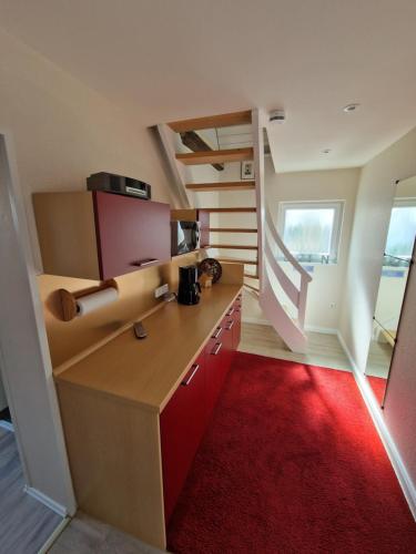 a room with a desk with a red rug at Altes Zollhaus in Fehmarn