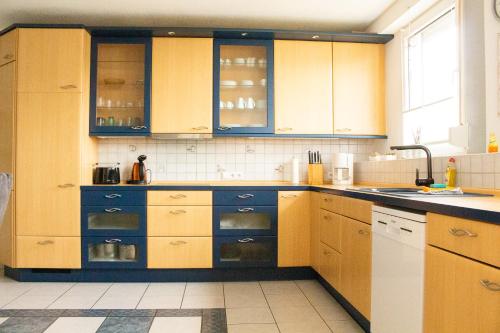uma cozinha com armários de madeira e um lavatório em Ferienwohnung Welcome em Telgte