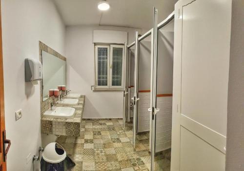 Baño con 2 lavabos y espejo en Bed Station Hostel & Bar en Shkodër