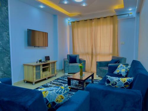 a living room with two blue couches and a tv at سى فيو السريا in Alexandria