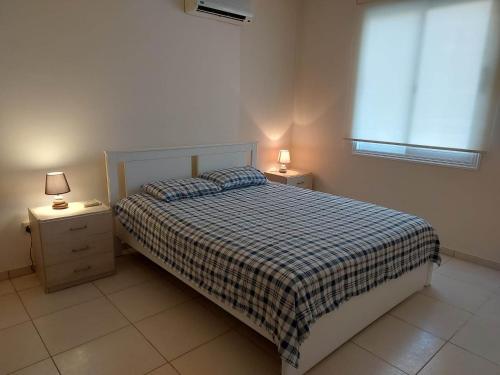 1 dormitorio con 1 cama con 2 mesitas de noche y 2 lámparas en Pyla Palms - Ground Floor, en Pyla