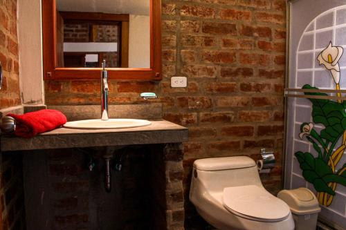 a bathroom with a sink and a toilet at Comunidad La Moya, Calpi in Riobamba