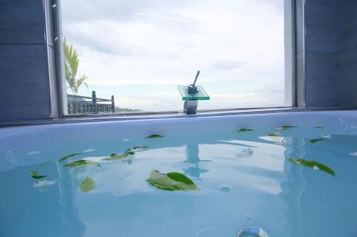 a bathtub with a window with a view of the ocean at Ro Yo Rock Ella in Ella