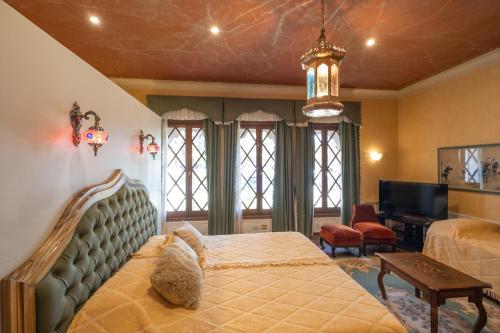 sypialnia z dużym łóżkiem i telewizorem w obiekcie Augusta Palace w mieście Salta