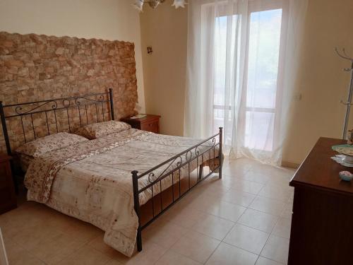 1 dormitorio con cama y ventana grande en Belvedere Apartment en SantʼAlfio