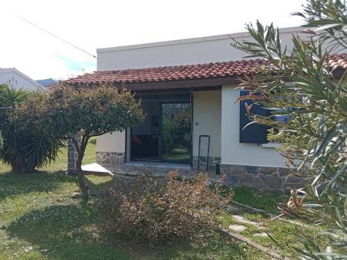 a small white house with a door in a yard at SANTA-LUCIA in Santa-Lucia-di-Moriani