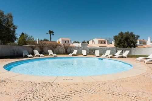 a swimming pool with lounge chairs and a swimming pool at Aldeia do Golfe - Private condominium by HD in Vilamoura