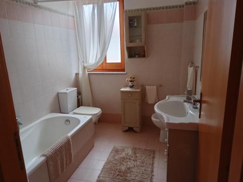 y baño con bañera, aseo y lavamanos. en Belvedere Apartment en SantʼAlfio