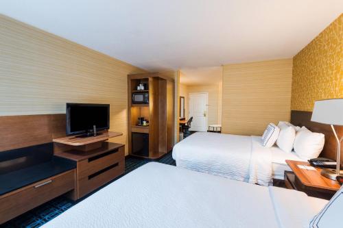 a hotel room with two beds and a flat screen tv at Fairfield by Marriott Inn & Suites Uncasville Mohegan Sun Area in Uncasville
