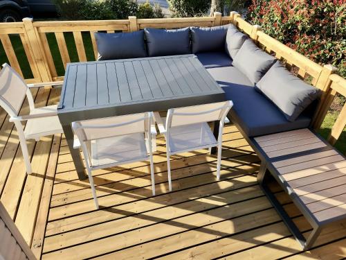 a couch and two chairs and a table on a deck at Mobilhome - Kedidrouz du Léon - Kerlann - Pont Aven in Pont-Aven