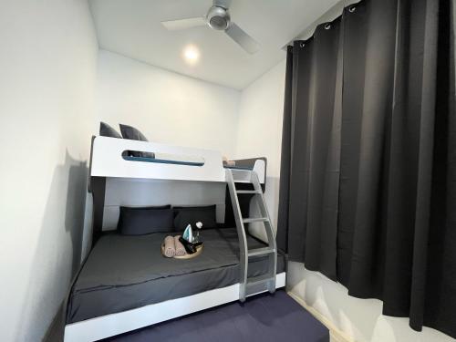 a bunk bed in a small room with black curtains at D'pristine by Antlerzone in Johor Bahru