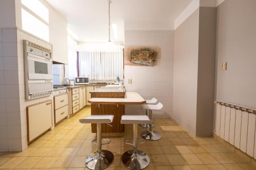 a kitchen with a table and some stools in it at Augusta Palace in Salta