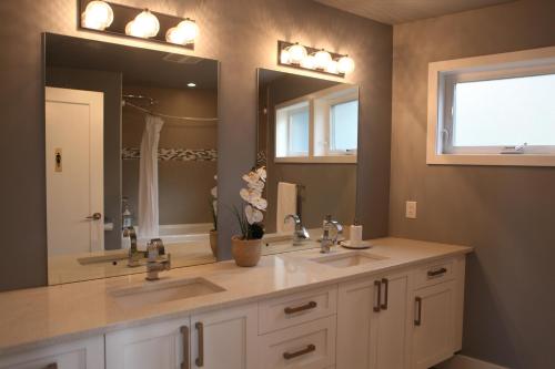 a bathroom with two sinks and a large mirror at Galloping Goose B&B in Beautiful Victoria in Victoria