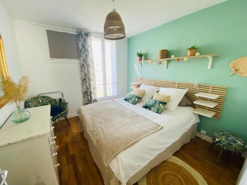 une chambre avec un grand lit aux murs bleus dans l'établissement Le cocon du peintre - Brest centre, à Brest