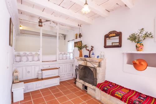 a living room with a fireplace and a couch at Olive Grove Cottage in Karpathos Town