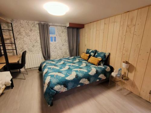 a bedroom with a bed with a blue comforter at Maison avec sous sol indépendant et parking à 2km de Versailles in Buc