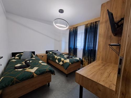 een slaapkamer met 2 bedden en een tafel. bij Apartament NATA in Zakopane