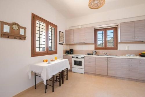 a kitchen with a table with chairs and a stove at Angelika House -Amazing Sea view in Moírai