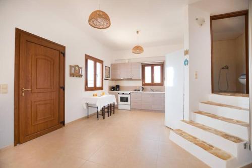 a kitchen with a staircase and a table and a door at Angelika House -Amazing Sea view in Moírai