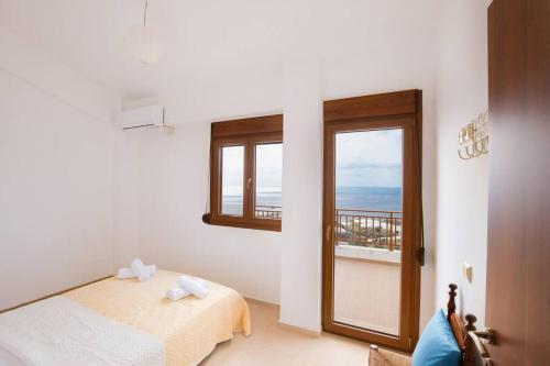 a bedroom with a bed and a view of the ocean at Angelika House -Amazing Sea view in Moírai