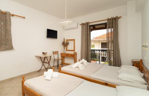 a bedroom with two beds and a window at Tsimiklis Apartments in Finikounta