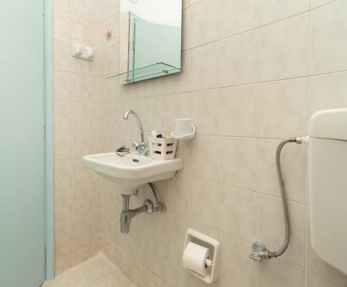 y baño con lavabo y espejo. en Tsimiklis Apartments, en Finikounta