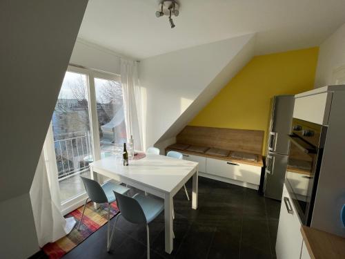 eine Küche mit einem weißen Tisch und Stühlen in der Unterkunft Loft mit 2 Terrassen - ruhig&sonnig in Leipzig