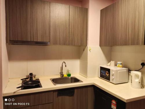 a kitchen with a sink and a microwave at HP402- Two Bedroom Apartment- Wifi- Netflix- Parking- Cyberjaya -New, 3061 in Cyberjaya