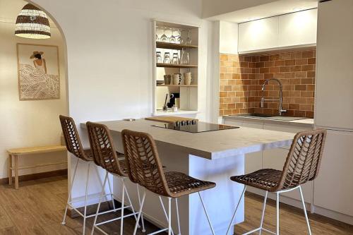 une cuisine avec un comptoir avec des chaises et un îlot de cuisine dans l'établissement Chez Joan, Apt de Standing, 4 Prs, à 300m des plages, à Antibes