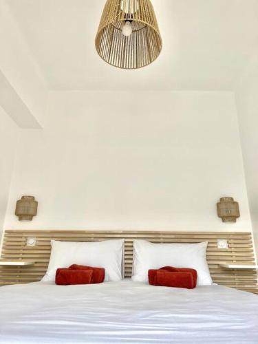 une chambre avec un lit blanc avec des oreillers rouges dans l'établissement Chez Joan, Apt de Standing, 4 Prs, à 300m des plages, à Antibes