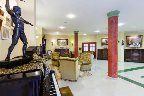 a living room with a statue of a man playing a piano at BURSZTYN - BERNSTEIN SPA & Wellness in Dąbki