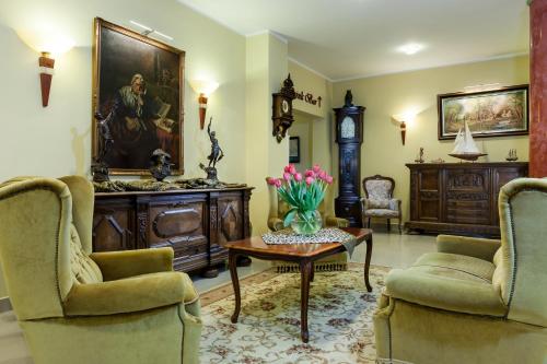 a living room with two chairs and a table with flowers on it at BURSZTYN - BERNSTEIN SPA & Wellness in Dąbki