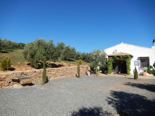 a white building with a stone wall and a yard at Villa San Nicolas - private, tranquil, relaxing.. in Ermita Nueva