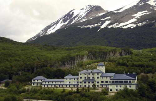 un grande edificio di fronte a una montagna di Los Acebos Ushuaia Hotel a Ushuaia