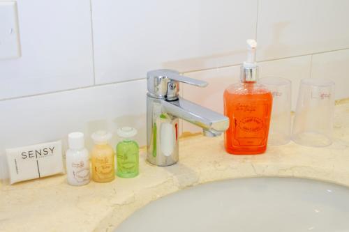 a bathroom sink with bottles of soap and a faucet at Hotel Casa de la Vega in Bogotá