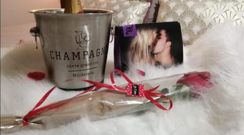 a bottle of champagne and a cup of lipstick at Spa-Sauna-Ciel de pluie tropicale-Champagne Nuit Romantique - Escapade Mâconnaise in Mâcon