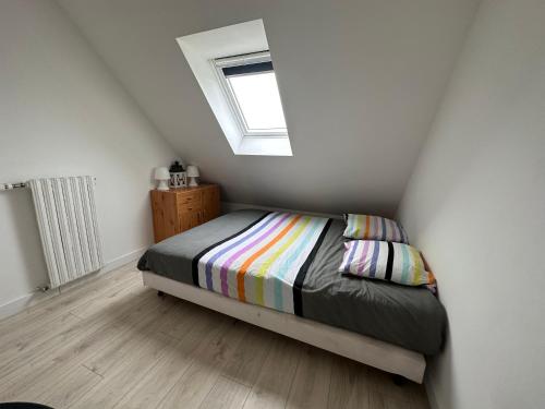 Dormitorio pequeño con cama y ventana en Breizh Horizon, en Tréméven