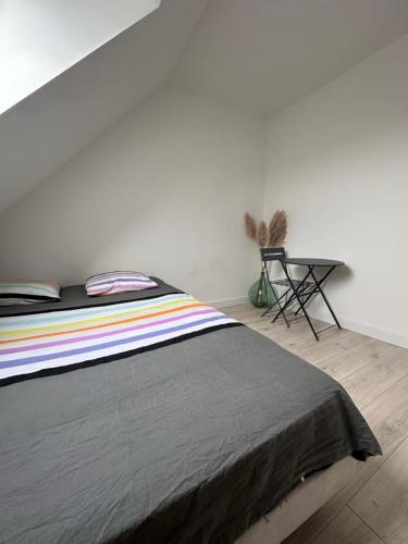1 dormitorio con 1 cama y mesa auxiliar en Breizh Horizon, en Tréméven