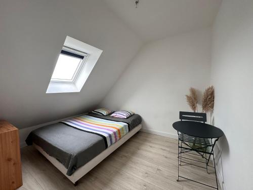 niewielka sypialnia z łóżkiem i oknem w obiekcie Breizh Horizon w mieście Tréméven