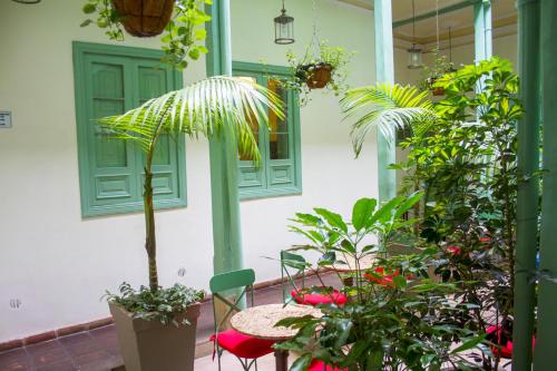 a patio with a table and chairs and plants at Hotel Casa de la Vega in Bogotá