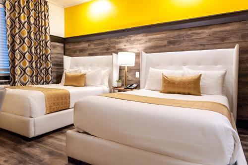 two beds in a hotel room with yellow walls at Catalina Hotel & Beach Club in Miami Beach