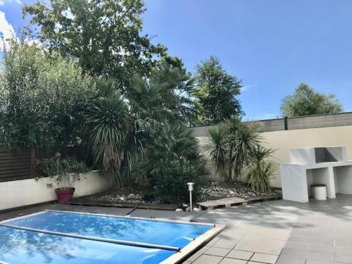 una piscina in un cortile con recinzione e alberi di Maison piscine 4 ch Carcans Médoc Bassin Arcachon a Carcans