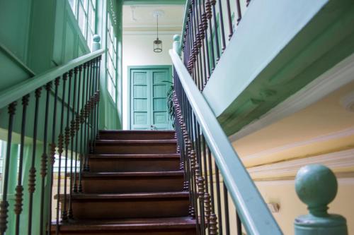 a stairway in a house with green walls and wooden stairs at Hotel Casa de la Vega in Bogotá