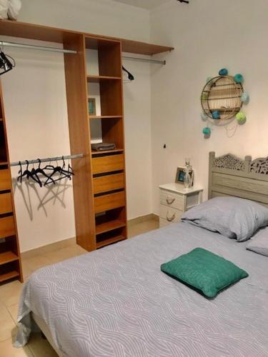 - une chambre dotée d'un lit avec un oreiller vert dans l'établissement Maison piscine 4 ch Carcans Médoc Bassin Arcachon, à Carcans