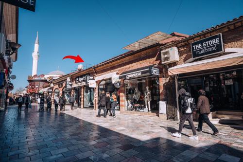 een groep mensen die door een straat lopen met winkels bij Darni Central Apartments - Bazaar Location With Free Parking in Ohrid