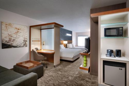 um quarto de hotel com um quarto com uma cama e uma televisão em SpringHill Suites by Marriott Provo em Provo