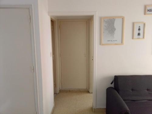 a hallway with a door and a couch in a room at El depto de Nico in Mar del Plata