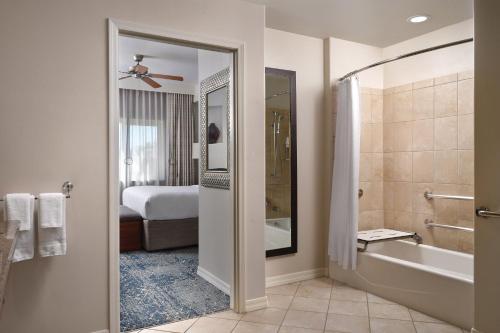 ein Bad mit einer Dusche, einer Badewanne und einem Bett in der Unterkunft Sheraton Desert Oasis Villas, Scottsdale in Scottsdale