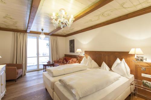 a bedroom with a large bed and a chandelier at Theresa Wellness-Genießer-Hotel in Zell am Ziller